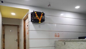 Una habitación de hotel con piso de mármol, un mostrador de recepción y una puerta con marco de madera.