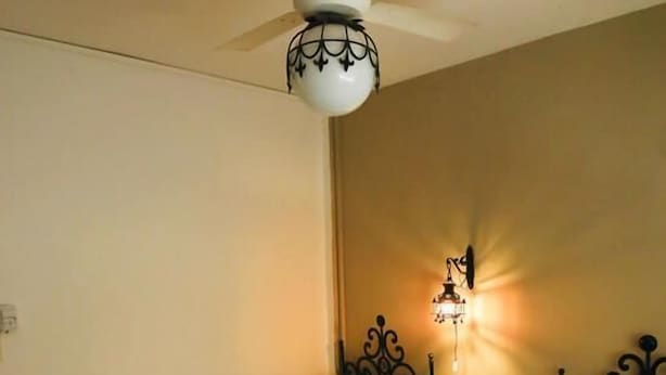 A room with two beds, a ceiling fan, and a wall-mounted light fixture. - Hotel Palmar (Colon)