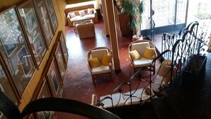 A spacious lobby with wicker furniture, a staircase, and large windows. - Hotel Palmar (Colon)