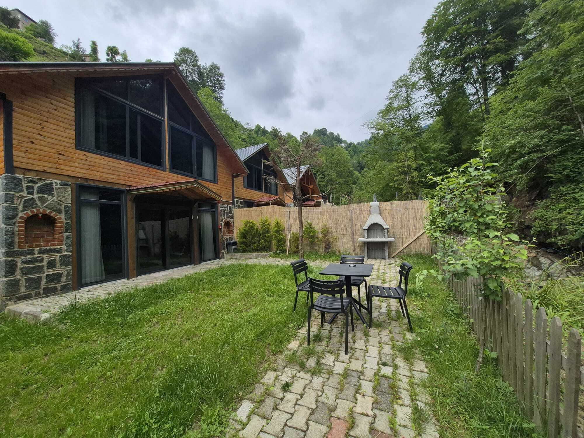 A house with a stone facade, a wooden deck, and a barbecue area.