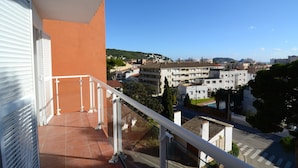 A balcony with a metal railing overlooking a residential area with buildings and a clear sky. - Apartment in Spain Near Sandy Beach (Torroella de Montgrí)