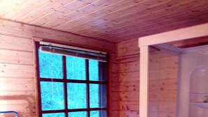A wooden-paneled bathroom with a window, a toilet, a sink, and a shower. - Atelier du Moulin all in wood classified 2 * for 2 to 4 pers - on the banks of the torrent (Aubusson-d'Auvergne)