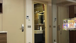 Une chambre d’hôtel équipée d’un lit, d’une télévision, d’une salle de bain et d’une armoire.