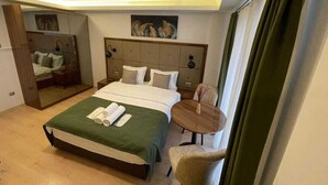 Une chambre d’hôtel avec un grand lit, une petite table ronde et un miroir.