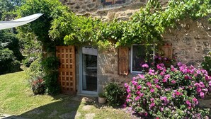 A stone house with a wooden door and windows, surrounded by a garden with pink flowers and greenery. - Couple's Retreat in Vineyard House with Terrace (Tailhac)