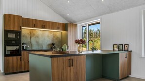 Een moderne keuken met houten kastjes, een centraal eiland en ingebouwde apparatuur.