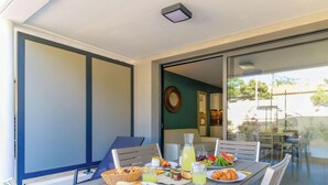A dining area with a table set for breakfast, including croissants, fruit, and beverages. - Charming apartment in La Favière, pets allowed, near beaches (Bormes-les-Mimosas)