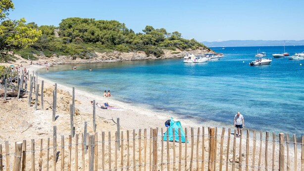 A beach with clear blue water, a sandy shore, and boats in the distance. - Charming apartment in La Favière, pets allowed, near beaches (Bormes-les-Mimosas)