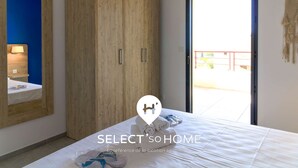 A bedroom with a large wardrobe, a bed with neatly folded towels, and a view of the outside through a door. - Bright apartment with large terrace and pool, Le Lavandou (Le Lavandou)