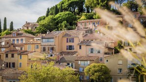 A hillside town with traditional buildings, some with balconies, under a clear sky.