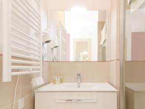 A bathroom with a white sink, mirror, and towel rack.