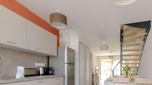 A modern kitchen with a stainless steel refrigerator, a kettle, and a toaster. There is a staircase leading to another level. - Modern duplex with pool and garden, for 6 in Bormes-les-Mimosas (Bormes-les-Mimosas)