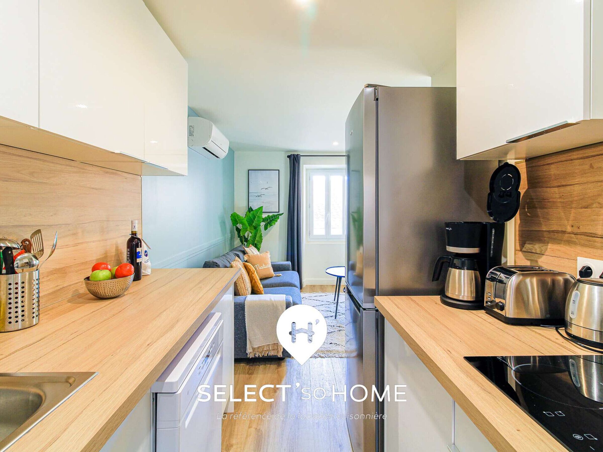 A modern kitchen with a dishwasher, coffee maker, toaster, and an induction cooktop.