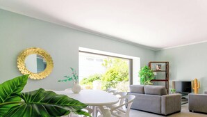 A modern living room with a dining area, a grey sofa, a television, and a cactus decoration. - Stunning Villa 8 pers - Jacuzzi - Large Spaces (Le Lavandou)