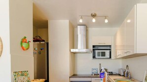 A compact kitchen with a refrigerator, microwave, and a small countertop. - Duplex in Lavandou, Pets Allowed, Parking (Le Lavandou)