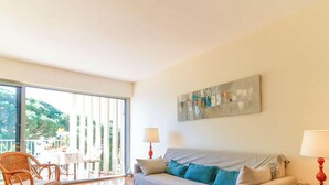 A living room with a grey sofa, teal cushions, a red lamp, and a large abstract painting on the wall. - Duplex in Lavandou, Pets Allowed, Parking (Le Lavandou)