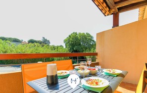 An outdoor dining area with a table set for two, featuring plates of food, glasses, and a coffee pot. - 2-room apartment with private parking and terrace, steps from Saint-Clair beach (Le Lavandou)