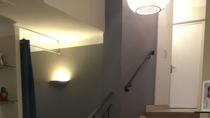 A staircase with beige steps and a black handrail, leading to a landing with a white door. - Detached villa (Marguerittes)