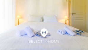 A hotel room with a large bed, two bedside lamps, and neatly folded towels on the bed. - Bright loft in Le Lavandou center, pets allowed, 2 bedrooms (Le Lavandou)