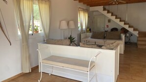 A spacious living area with a white sofa, a bench, and a staircase leading to an upper level. - Villa Can Susacasa relax with sun swimming pool air conditioning and unobstructed views  (Santa Margalida)