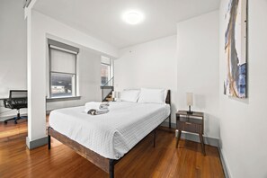 A modern bedroom with a large bed, a desk, and a chair. - Chic & comfy unit in Louisville's Medical District (Louisville)