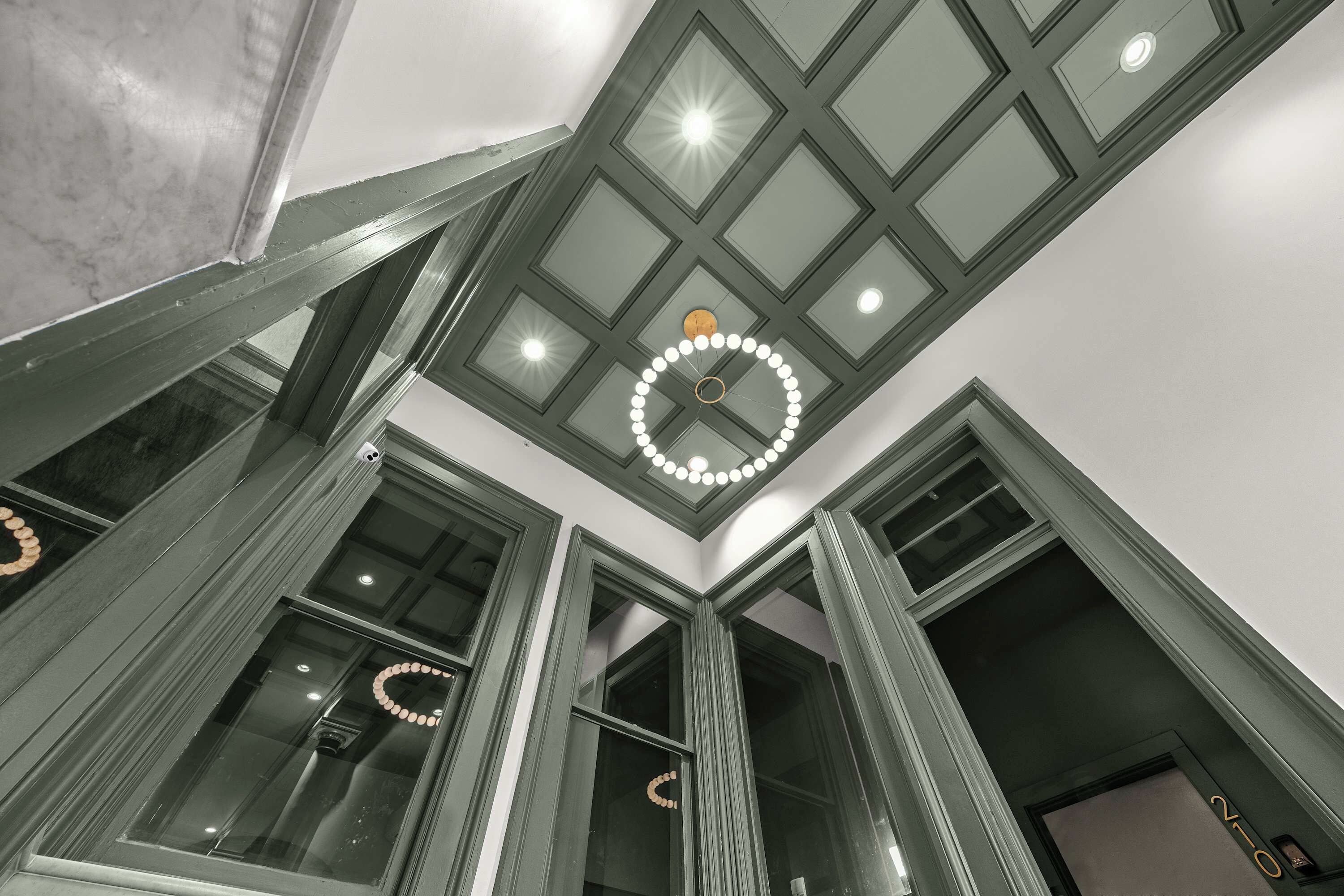 A high ceiling with a skylight and a circular light fixture.