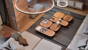 A modern living room with a wooden coffee table, sofa, and hanging pendant lights.