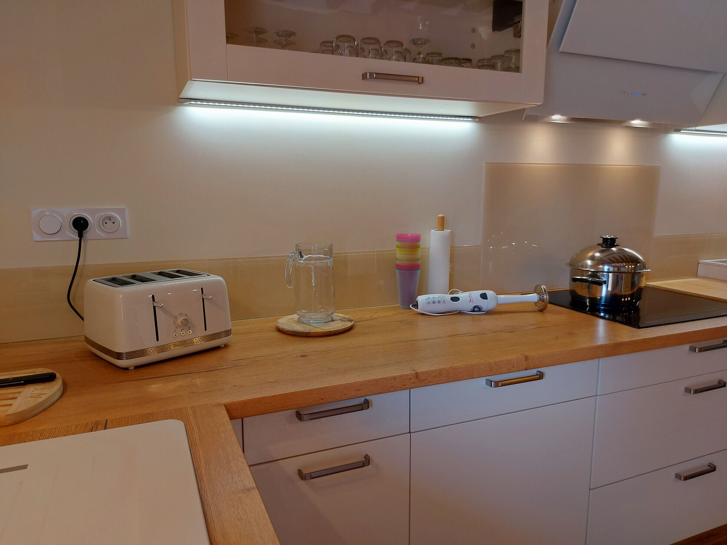 A kitchen with a toaster, a kettle, and a stove.
