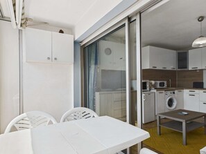 A compact kitchen with a washing machine, microwave, and cabinets.