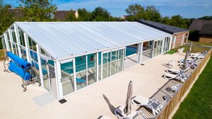 A modern building with a glass facade, a pool, and outdoor seating. - Chalet in Normandy Near Veules-les-roses (Veules-les-Roses)