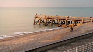 A wooden pier extending into calm waters with a pebbled beach and a concrete barrier. - Chalet in Normandy Near Veules-les-roses (Veules-les-Roses)