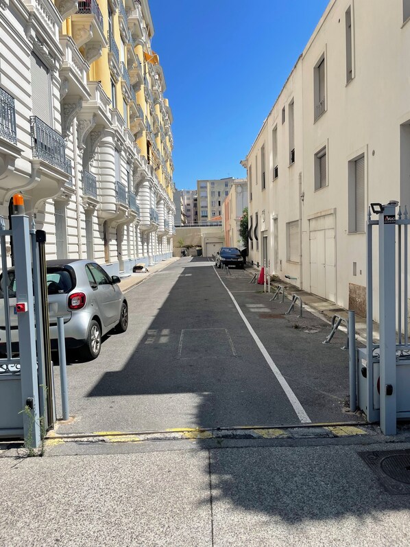 Eine enge Straße mit parkenden Autos und Gebäuden an beiden Seiten.