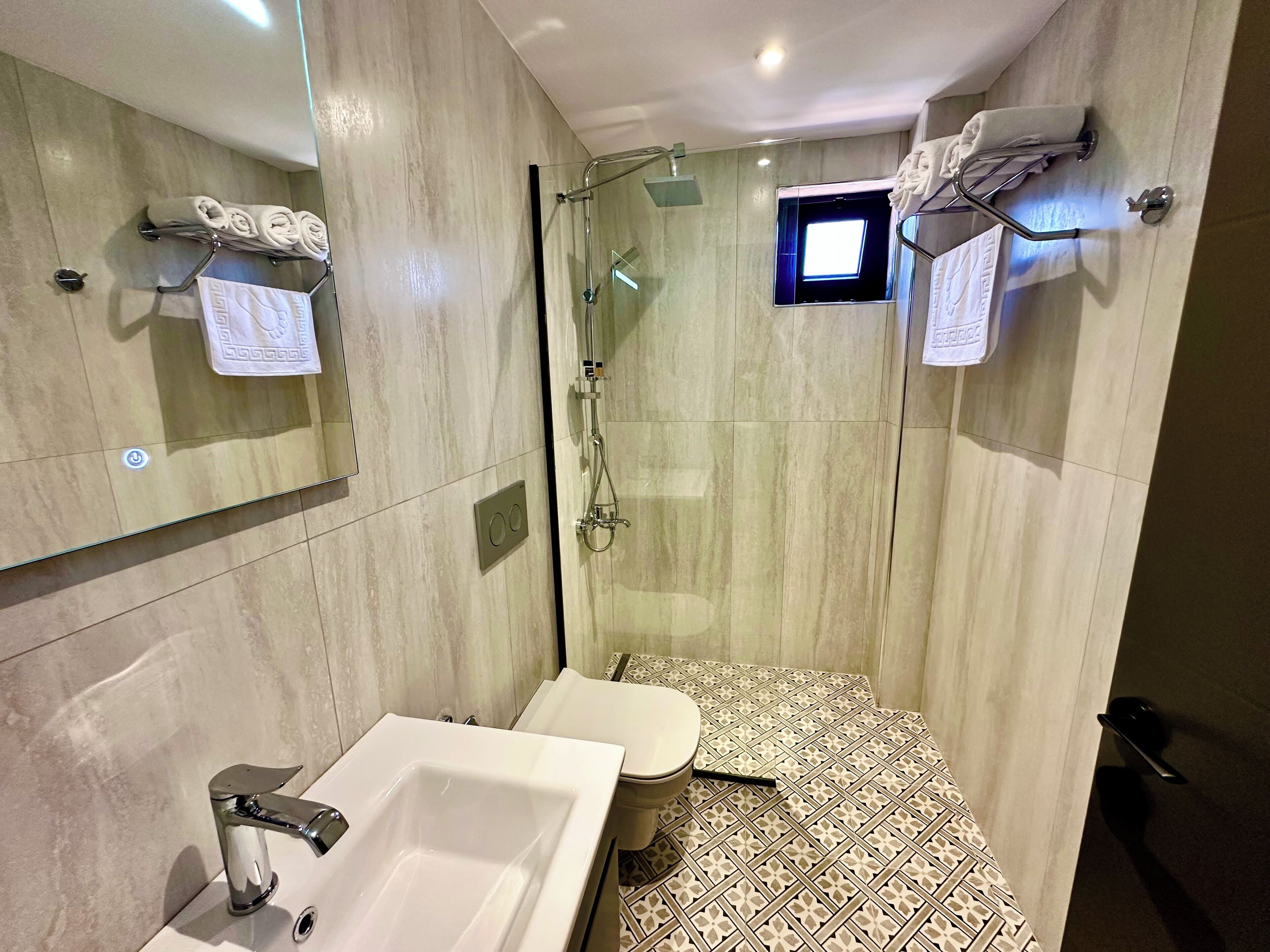 Un baño moderno con ducha, lavamanos e inodoro.