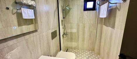 Un baño moderno con ducha, lavamanos e inodoro.