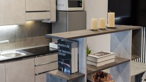 A modern kitchen with a microwave, a flat-screen TV, and a book titled "Architecture in the Twentieth Century" on a shelf. - The Little Etruscan, cozy tourist rental in the center of Arezzo (Arezzo)