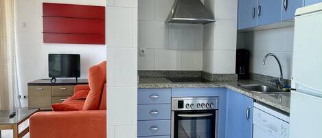 A compact kitchen with a built-in oven, a microwave, and a stainless steel range hood.