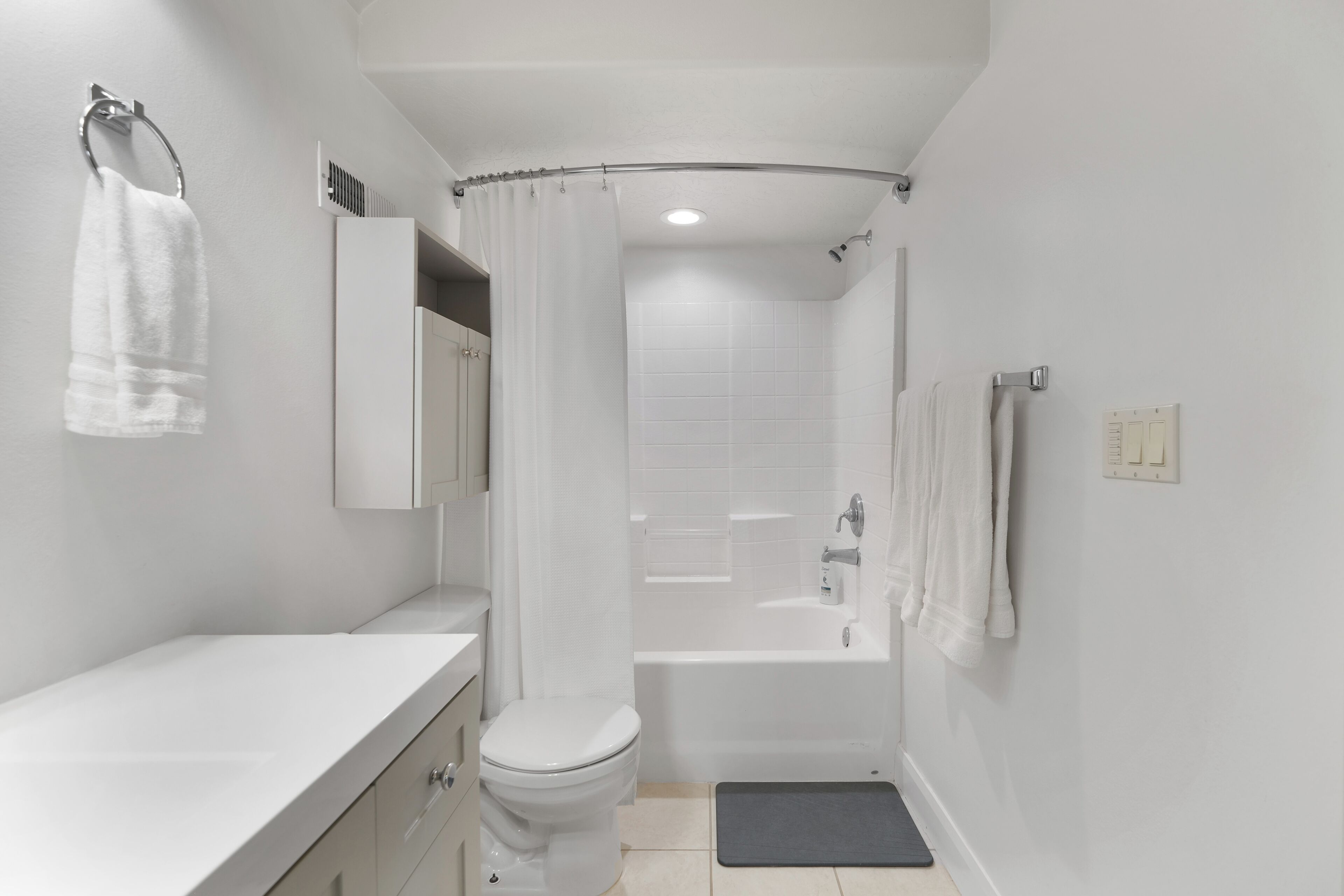 A modern bathroom with a toilet, sink, bathtub, and shower.