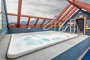 A hot tub in a covered outdoor area with a view of mountains.