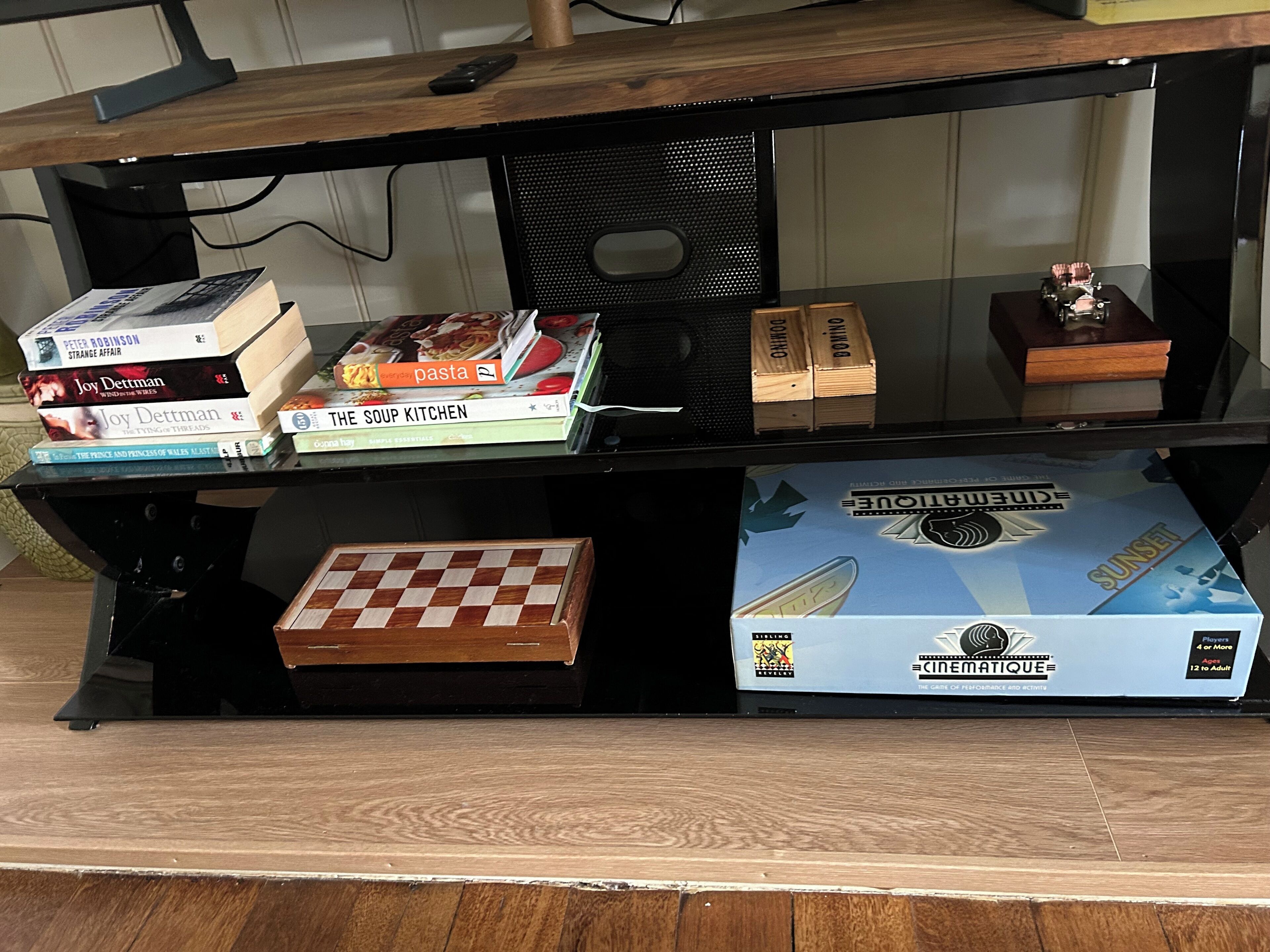 A wooden desk with a computer monitor, a chessboard, and several books.