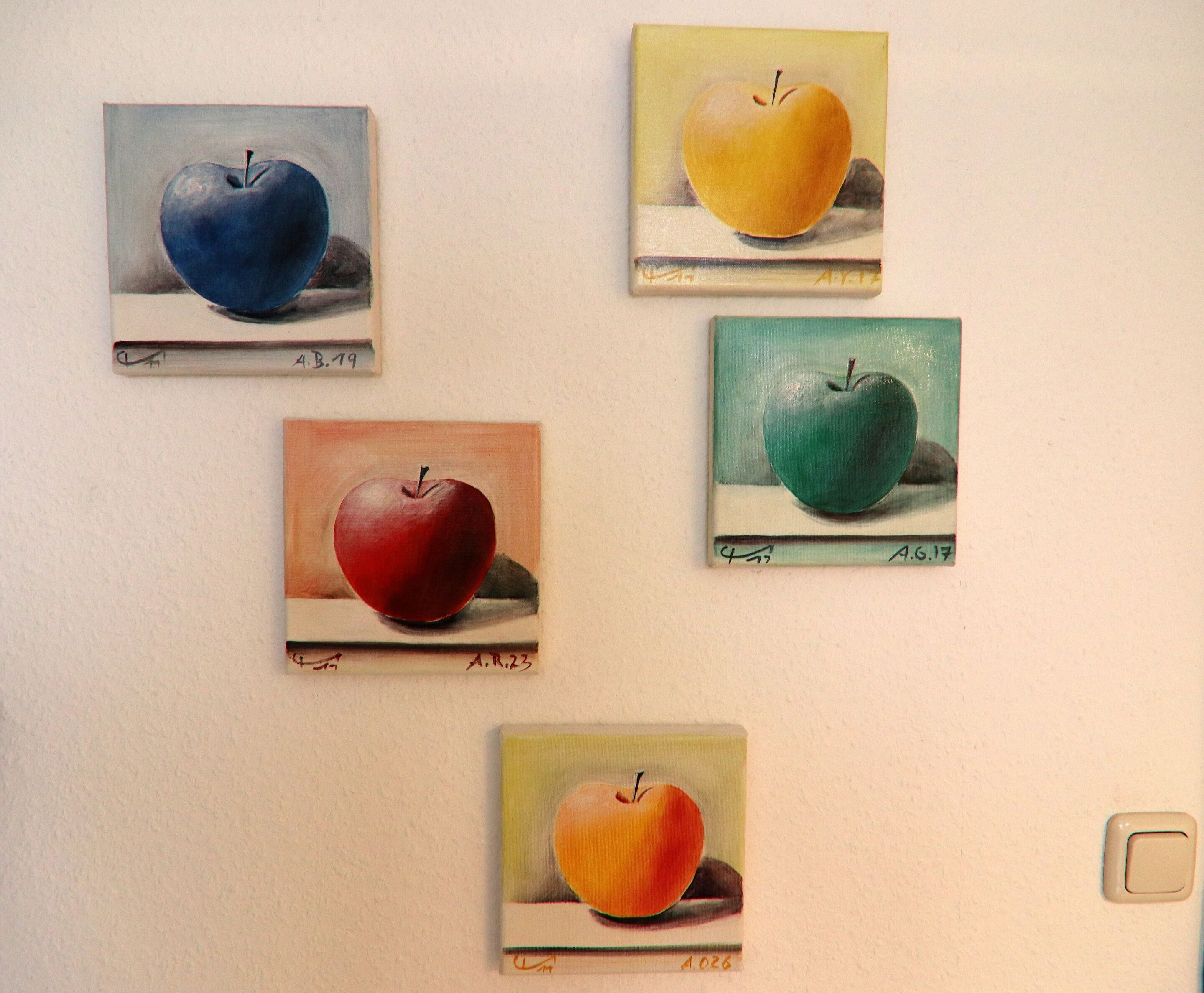 Cuatro cuadros de manzanas en una pared.