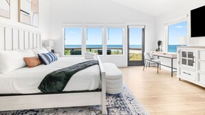 A bedroom with a bed, a desk, and a view of the ocean. - Luxury Ocean Front, Near Downtown, Heated Pool, Hot Tub, Game Room, Sleeps 28 (St. Augustine)