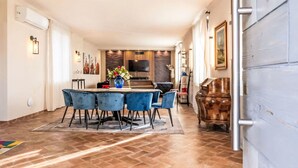 A spacious dining area with a long table, blue chairs, and a vase of flowers. - Beautiful private villa for 24 guests with WIFI, private pool, A/C, TV and patio (Stroncone)