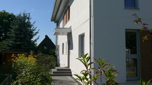 A modern two-story house with a white exterior, a visible front door, and a small porch. - Hamburg Wedel Apartment NORDLICHT on the Elbe (Wedel)