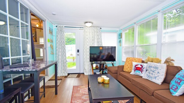 Una sala de estar con televisor, sofá y mesa de centro.