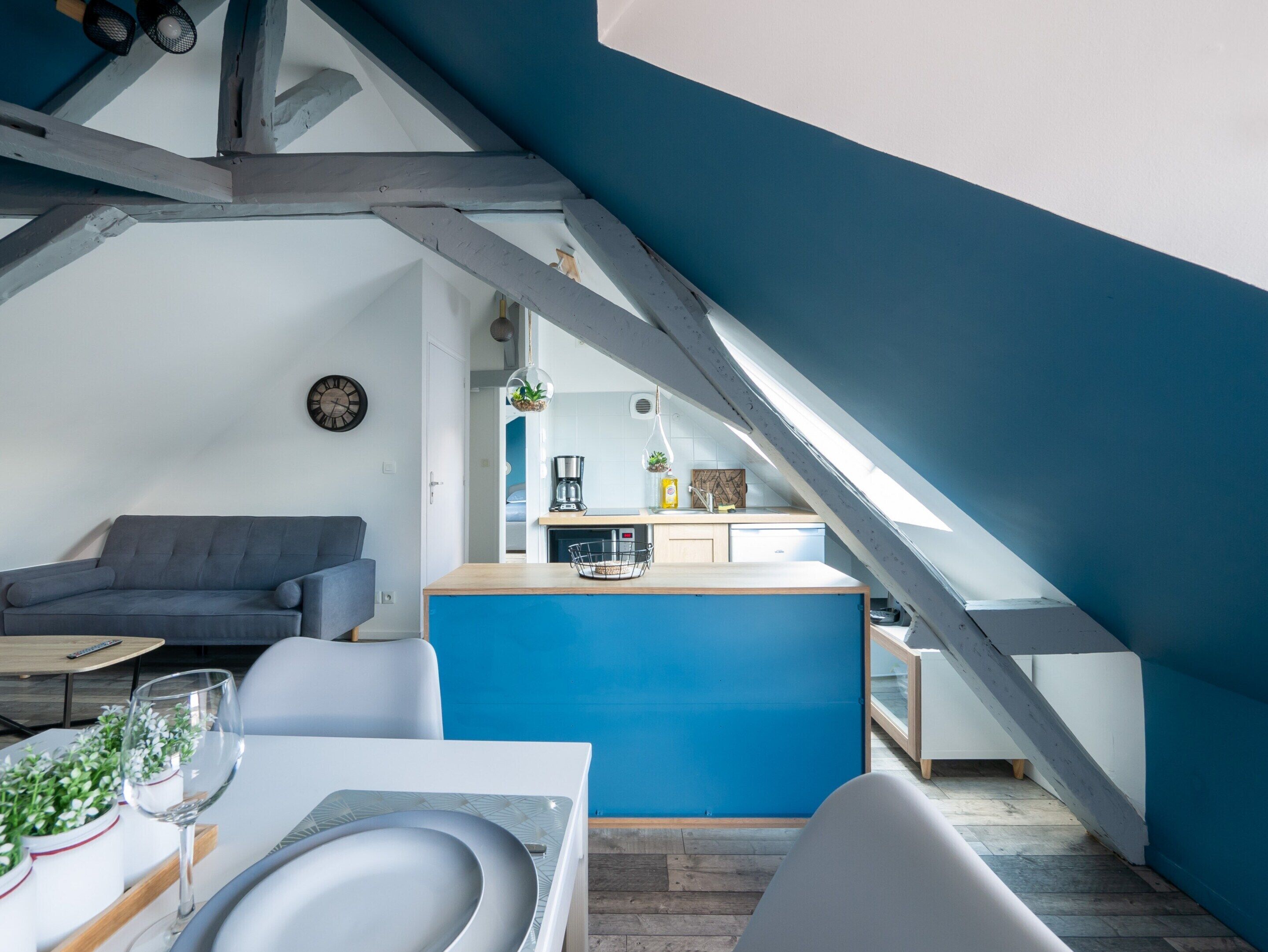 A modern loft apartment with a kitchen, dining area, and living space.