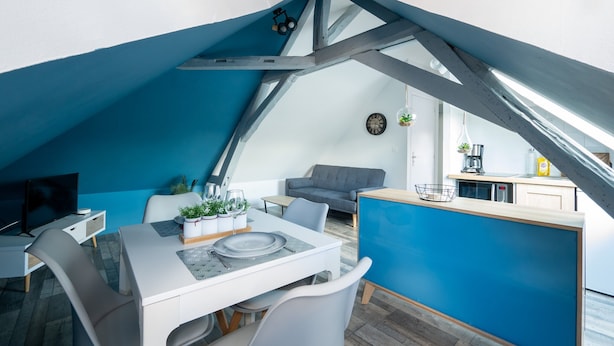A modern loft apartment with a dining area, kitchen, and seating space. - Chic Apartment Near City Center (Ecommoy)