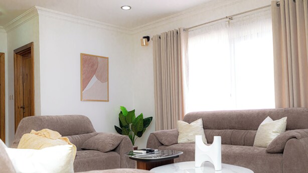 A living room with two sofas, a coffee table, and a potted plant. - Polo Heights -Sky Suites (Accra)
