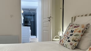 A bedroom with a bed, a door leading to a bathroom, and a visible shower area. - Apartment in Le Mans With Private Terrace (Le Mans)