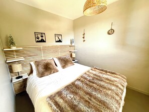 A bedroom with a bed, bedside tables, a lamp, wall art, and a hanging light fixture. - 2-room apartment with a view of the ski slopes (Allos)