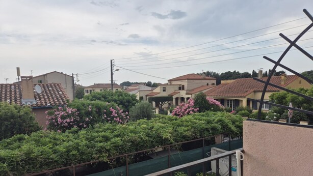 Zona residencial amb cases, verdor i un jardí tancat.